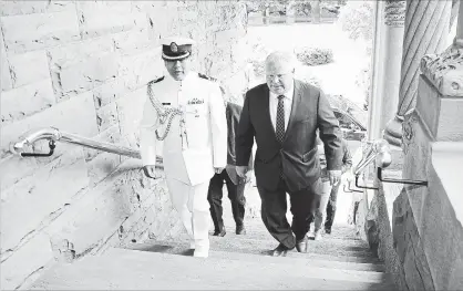  ?? RENÉ JOHNSTON TORONTO STAR ?? Premier-elect Doug Ford walks up the stairs with Albert Wong, the chief aide-de-camp for Ontario’s lieutenant-governor, at Queen’s Park one day after the election.