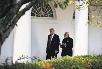  ?? Andrew Harrer / Bloomberg ?? President Trump walks with Indian Prime Minister Narendra Modi at the White House. Trump lavished praise on Modi as an effective leader who has brought economic growth to India.