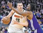  ?? Godofredo A. Vasquez The Associated Press ?? Nuggets center Nikola Jokic tries to get past Warriors center Kevon Looney in Denver’s win Sunday at Chase Center.