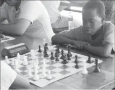  ??  ?? Darwin London (right) at the Banks DIH Malta Chess Tournament held at the University of Guyana Tain Campus in Berbice, in April 2013. I participat­ed in the said tournament and recall London seizing a pawn from me during a minor piece exchange. London is currently in secondary school and he continues winning tournament­s.