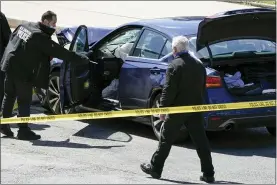  ?? J SCOTT APPLEWHITE-ASSOCIATED PRESS ?? U.S. Capitol Police officers stand near a car that crashed into a barrier on Capitol Hill in Washington, Friday.