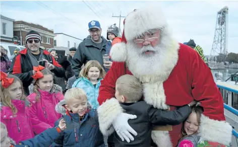  ?? PHOTOS BY MICHELLE ALLENBERG/ WELLAND TRIBUNE ?? Santa Claus is welcomed by a large group of people on West Street in Port Colborne after arriving in the city via tug boat Saturday.