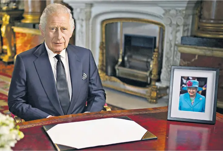  ?? ?? King Charles III delivers his address to the nation and the Commonweal­th from Buckingham Palace, next to a photograph of the late Queen