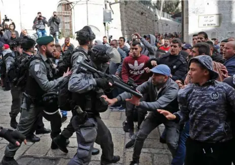  ?? THOMAS COEX/AFP/GETTY IMAGES ?? Israeli security forces and Palestinia­n protesters clash in Jerusalem’s Old City Friday. Four Palestinia­ns were killed and dozens more were injured.