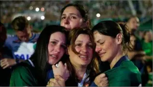  ??  ?? Relatives of Chapecoens­e soccer players cry during a memorial inside the team’s stadium