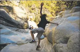  ?? Wally Skalij Los Angeles Times ?? A BOY plays at Hermit Falls, one of the most popular waterfalls in the area. The proximity of Angeles National Forest to L.A. can give people a false sense of safety.