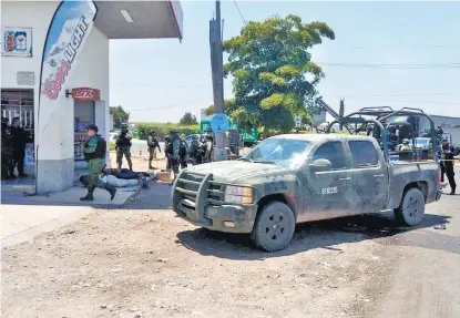  ??  ?? Efectivos del Ejército rodean a varios pistoleros luego de la balacera sobre la carretera Culiacán-Eldorado