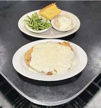  ??  ?? Chicken-fried steak comes with sides like green beans, mashed potatoes with gravy and cornbread at 410 Diner on Broadway.
