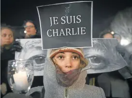  ?? Picture: CARLO ALLEGRI/REUTERS ?? I AM CHARLIE: Amandine Marbach, from Strasbourg, France, at a vigil in New York for the victims of the Charlie Hebdo massacre