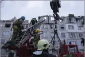  ?? PHOTOS BY EVGENIY MALOLETKA — THE ASSOCIATED PRESS ?? Rescue workers climb by ladder as they clear the rubble of the residentia­l building which was destroyed by a Russian rocket in Pokrovsk, Ukraine, on Wednesday. According to local authoritie­s, two people were killed and 12 injured.