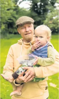  ??  ?? Picky eater Aurora Hamalainen­a munches on a berry with dad Antti