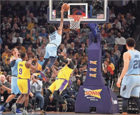  ?? MAX GERSH / THE COMMERCIAL APPEAL ?? Grizzlies' Ja Morant (12) is called with an offensive foul as he tries to dunk over Lakers' Anthony Davis (3) on Saturday, Feb. 29, 2020, during a game at Fedexforum in downtown Memphis.