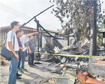  ??  ?? Wong (third left) points to one of the gutted houses in Kampung Bahagia Jaya,Teku here. With him on his right is Special Affairs Department (Jasa) officer for Sibu/Mukah division Awang Julaihi Awang Ali Bohan.