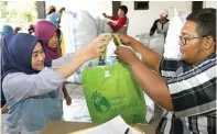  ?? ROBERTUS RISKY/JAWA POS ?? PRAKTIS: Erie Nurwahyuni­ngdyah (kiri) menyerahka­n botol plastik untuk ditukarkan dengan tiket Suroboyo Bus kemarin.