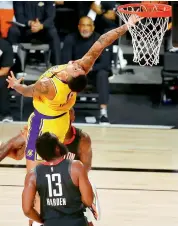  ?? — AP ?? Kyle Kuzma (in yellow) of the Los Angeles Lakers makes a backward shot against the Houston Rockets during their NBA game in Lake Buena Vista, Florida, on Thursday. The Rockets won 113-97.