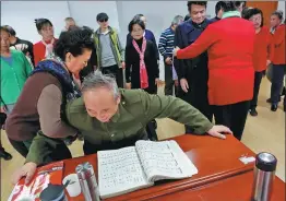  ??  ?? A student helps Ren to stand up and watch their chorus performanc­es at the New Year’s party.