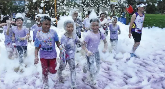  ?? SUNSTAR FOTO / RUEL ROSELLO ?? BUBBLE FUN. Participan­ts in the 30th Anniversar­y Celebratio­n Fartlek Run are treated to a bubble bath at the Cebu Business Park.