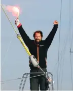  ?? — AFP ?? BREST, France: French skipper Thomas Coville holds a burning flare onboard his “Sodebo Ultim” trimaran as he arrives in this port in western France yesterday after beating the record in solo non-stop round-the-world sailing.