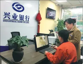  ?? CHEN JIA / CHINA DAILY ?? A worker (left) at Geely Auto Group’s Chunxiao Manufactur­ing Plant in Ningbo, Zhejiang province, applies for a consumer loan using online services of Industrial Bank.