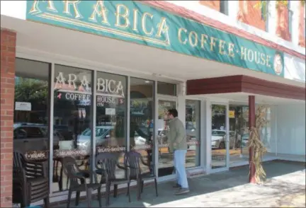  ?? KRISTI GARABRANDT — THE NEWS-HERALD ?? Downtown Willoughby business owner and longtime Arabica customer Pat Walsh finds out about the business’s sudden closing when he comes to get coffee on Oct. 16