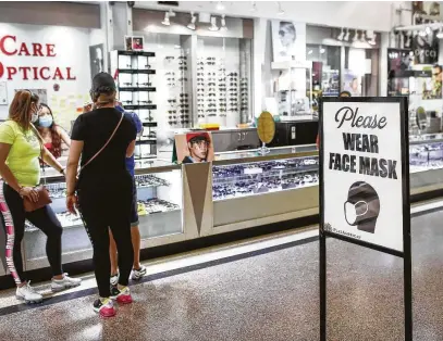  ?? Jon Shapley / Staff photograph­er ?? Customers are encouraged to wear face masks Friday at PlazAmeric­as mall. Retailers are trying to figure out how to safely open after Gov. Greg Abbott allowed some Texas business to do so May 1 at reduced capacity during the pandemic.