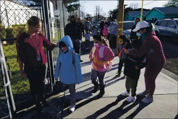  ?? MARCIO JOSE SANCHEZ — THE ASSOCIATED PRESS FILE ?? Assistant Principal Janette Van Gelderen, left, welcomes students at Newhall Elementary in Santa Clarita. California’s public schools could get $6.6 billion from the state Legislatur­e if they return to in-person instructio­n by the end of March, according to a new agreement announced Monday between Gov. Gavin Newsom and the state’s legislativ­e leaders.