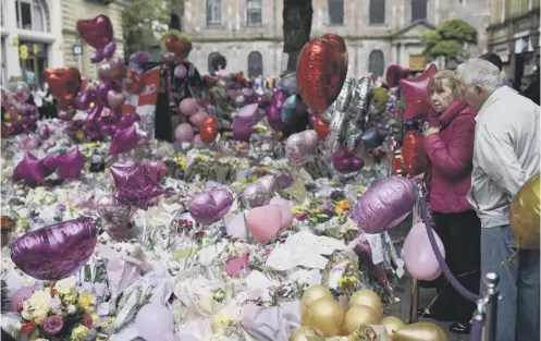  ?? PICTURE: AFP/GETTY IMAGES ?? 0 Floral tributes, pink balloons and messages of support are growing in St Ann’s Square in Manchester