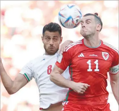  ?? (AFP) ?? Iran’s defender Morteza Pouraligan­ji (left) fights for the ball with Wales’ forward Gareth Bale during the Qatar 2022 World Cup Group B football match at the Ahmad Bin Ali Stadium on Friday.