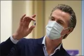  ?? JAE C. HONG — THE ASSOCIATED PRESS FILE ?? California Gov. Gavin Newsom holds up a vial of the Pfizer-BioNTech COVID-19 vaccine in Los Angeles.