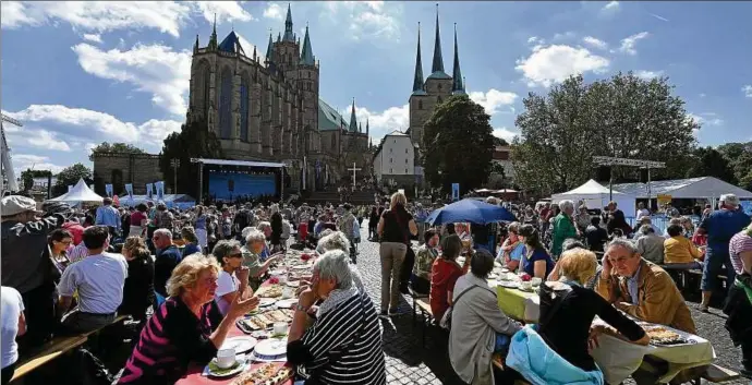  ?? Foto: Martin Schutt, dpa ?? Mit einem Familienka­ffee und  Thüringer Kuchen begann am Himmelfahr­tstag vor Dom und Severikirc­he auf dem Domplatz in Erfurt die Kirchentag­e auf dem Weg.