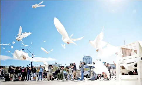 ??  ?? Doves are released for each victim of the Route 91 Harvest music festival mass shooting at City Hall plaza in Las Vegas. — Reuters photo