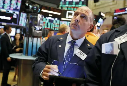  ?? RICHARD DREW- THE ASSOCIATED PRESS ?? Trader Michael Urkonis works on the floor of the New York Stock Exchange, Friday. Stocks are having a mixed performanc­e early on Wall Street Friday as gains in banks and energy companies are offset somewhat by a drop in technology stocks.