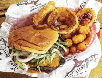  ?? Chuck Blount / Staff ?? This is a Big Juicy burger with cheddar cheese at the Longhorn Cafe, paired with tots and onion rings.