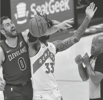  ?? KEN BLAZE/USA TODAY SPORTS ?? Cavaliers forward Kevin Love (0) and Raptors guard Gary Trent Jr. (33) battle for a jump ball as referee Marc Davis, right, reacts.