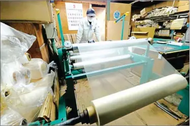  ?? KAZUHIRO NOGI/AFP ?? A worker checks a roll of the world’s thinnest washi paper at the Hidaka Washi factory in Hidaka, Kochi prefecture.