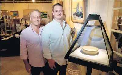  ?? SUSAN STOCKER/SOUTH FLORIDA SUN SENTINEL ?? Craig and Christophe­r Mayor of Abington Auction Gallery in Oakland Park recently sold a 1,000 year-old Chinese washer bowl for $412,500.