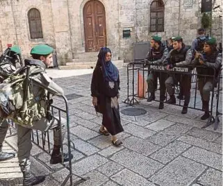  ??  ?? Seorang wanita Palestin melalui pusat kawalan tentera Israel di sekitar Masjid Al-aqsa.