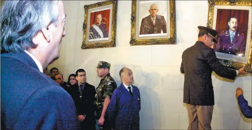  ?? ?? DECISIONES. El 24 de marzo de 2004, de bajar los cuadros de Jorge Rafael Videla y Reinaldo Bignone. La foto la sacó Víctor Bugge: el general Bendini retirando el cuadro de Videla, ante la mirada hierática de Kirchner.
Con la Ley de Medios se impedía que Clarín sea un contrapode­r.