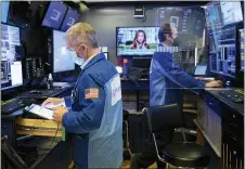  ?? COLIN ZIEMER — NEW YORK STOCK EXCHANGE VIA AP ?? In this photo provided by the New York Stock Exchange, trader Timothy Nick, left, and a colleague work in a booth on the trading floor, Tuesday, Jan. 19. 2021. Stocks are ticking higher on Wall Street Tuesday, recovering some of last week’s losses to pull closer to their record highs.