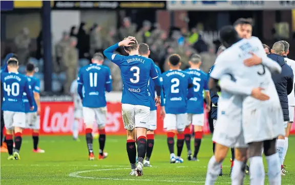  ?? Pictures: SNS. ?? Above: Dundee players celebrate as Rangers troop off Dens Park dejected after being held to a draw by 10-man Dark Blues on Sunday; Dee boss Jim McIntyre, opposite, salutes the home fans as his side extend their unbeaten run to four games.