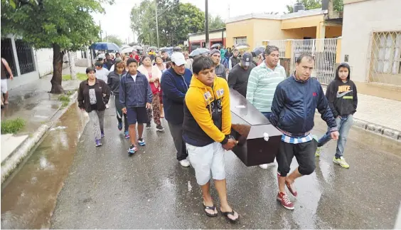  ?? LA GACETA ?? Despedida.Familiares y amigos de la víctima, el martes, mientras llevaban el cuerpo por las calles del barrio Ejército Argentino.