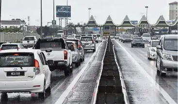  ??  ?? Are we there yet?: Motorists were mostly mainland-bound near the Juru toll plaza in Penang.