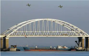  ?? Foto: Reuters / Pavel Rebrov ?? Russische Kampfjets flogen am Sonntag über die Brücke, die das russische Festland mit der annektiert­en Halbinsel Krim verbindet. Unten blockierte ein Schiff die Durchfahrt.