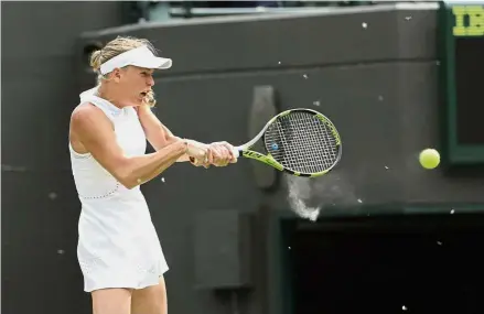  ??  ?? Bugs get in your eyes: Insects fly around as Caroline Wozniacki of Denmark returns a ball during her secondroun­d match against Ekaterina Makarova of Russia on Wednesday. — AP