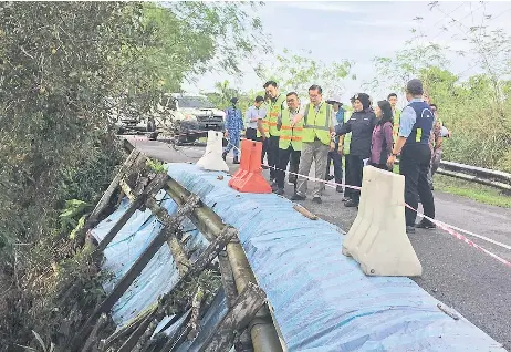  ?? ?? Lee (fourth right) checks out one of the landslide sites next to the main road to Kampung Haji Wahed.