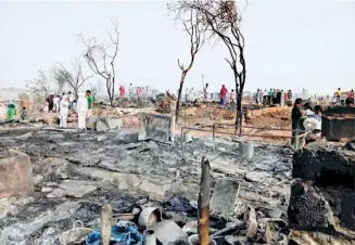  ??  ?? THE CAMP IN NUH DISTRICT, Haryana, where there was a fire on May 27. (Below) Ali Johar (centre) and Sabber Ahmad (in white T-shirt) at the camp the following day.