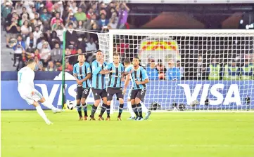  ??  ?? Real Madrid’s Portuguese forward Ronaldo (L) curls the ball over the Gremio wall to score from a free-kick during their FIFA Club World Cup 2017 final football match at Zayed Sports City Stadium in the Emirati capital Abu Dhabi on December 16, 2017. -...