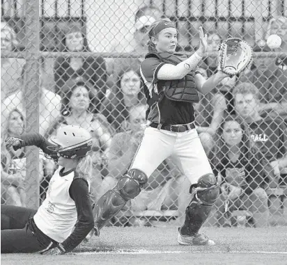  ?? MICHAEL LAUGHLIN/SUN SENTINEL ?? St. Thomas Aquinas’ Meagan Patterson scores in front of Spanish River catcher Rylie Brashears during their 8A regional game on Tuesday. semifinal softball