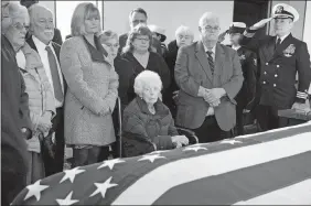  ?? MICHAEL DWYER/AP PHOTO ?? Rita Mendonsa, center, sits in front of theflag-draped casket of her husband, George, during funeral services at St. Columbia Cemetery in Middletown, R.I., on Friday. George Mendonsa, the sailor photograph­ed kissing a woman in Times Square at the end of World War II, died Sunday at age 95.