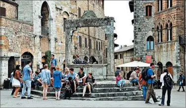  ?? CAMERON HEWITT/RICK STEVES’ EUROPE ?? Today’s tourists hang out at San Gimignano’s Piazza della Cisterna, by the same well locals used 1,000 years ago.